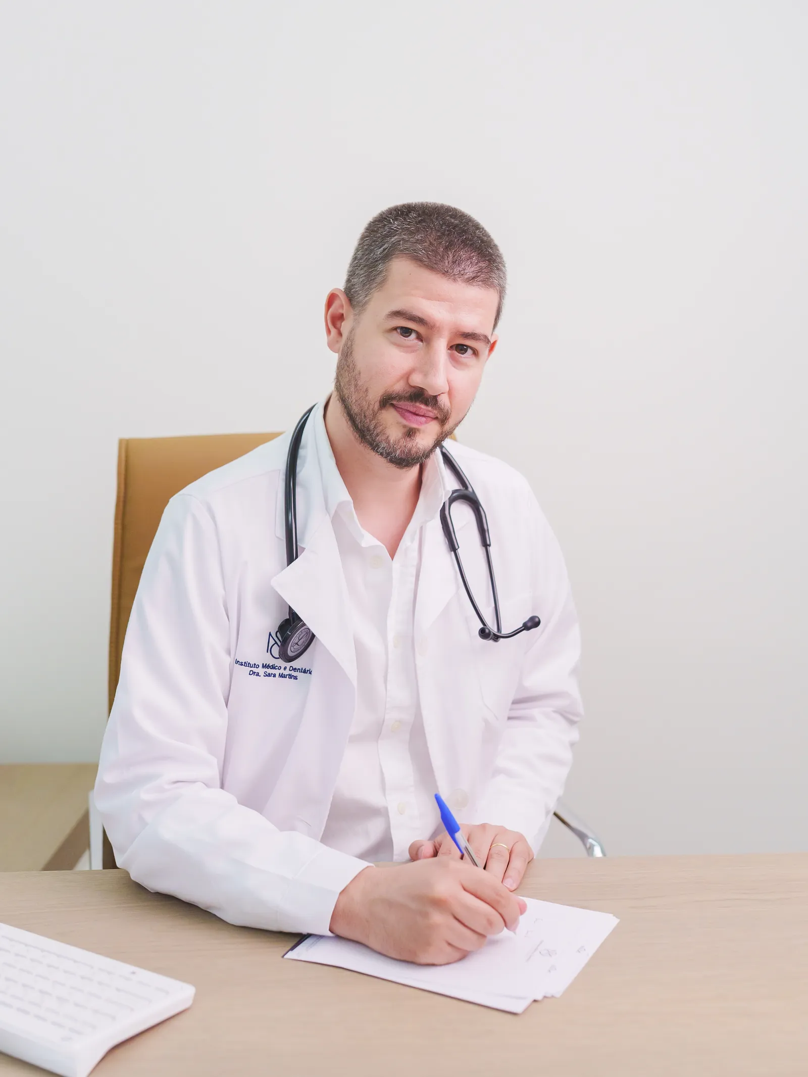 Médico a escrever à secretária numa consulta de Medicina Interna, no Instituto Médico e Dentário Dra. Sara Martins