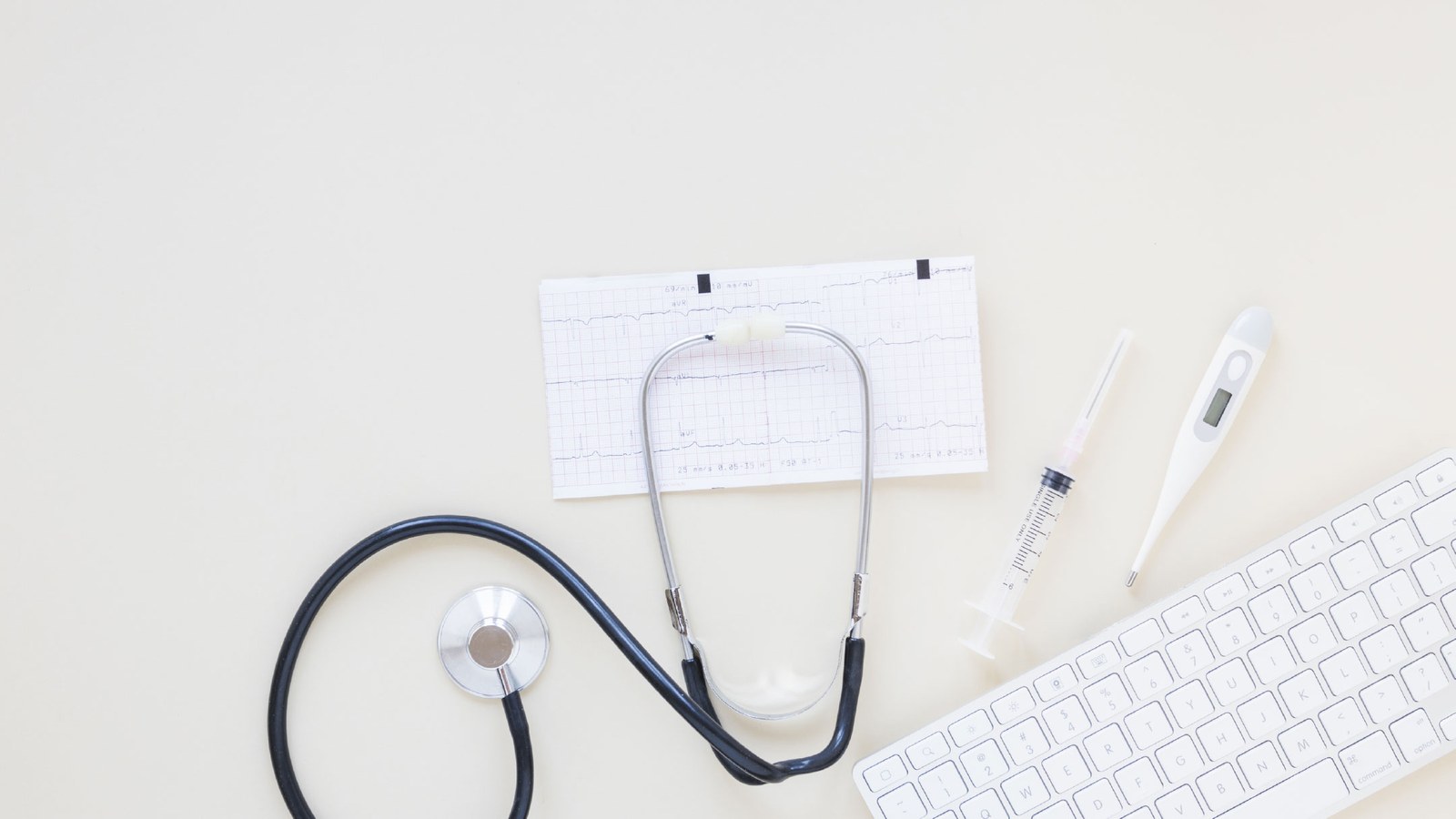 Estetoscópio e traçado de eletrocardiograma sobre secretária — avaliação cardiovascular e de tensão arterial no Instituto Médico e Dentário Dra. Sara Martins