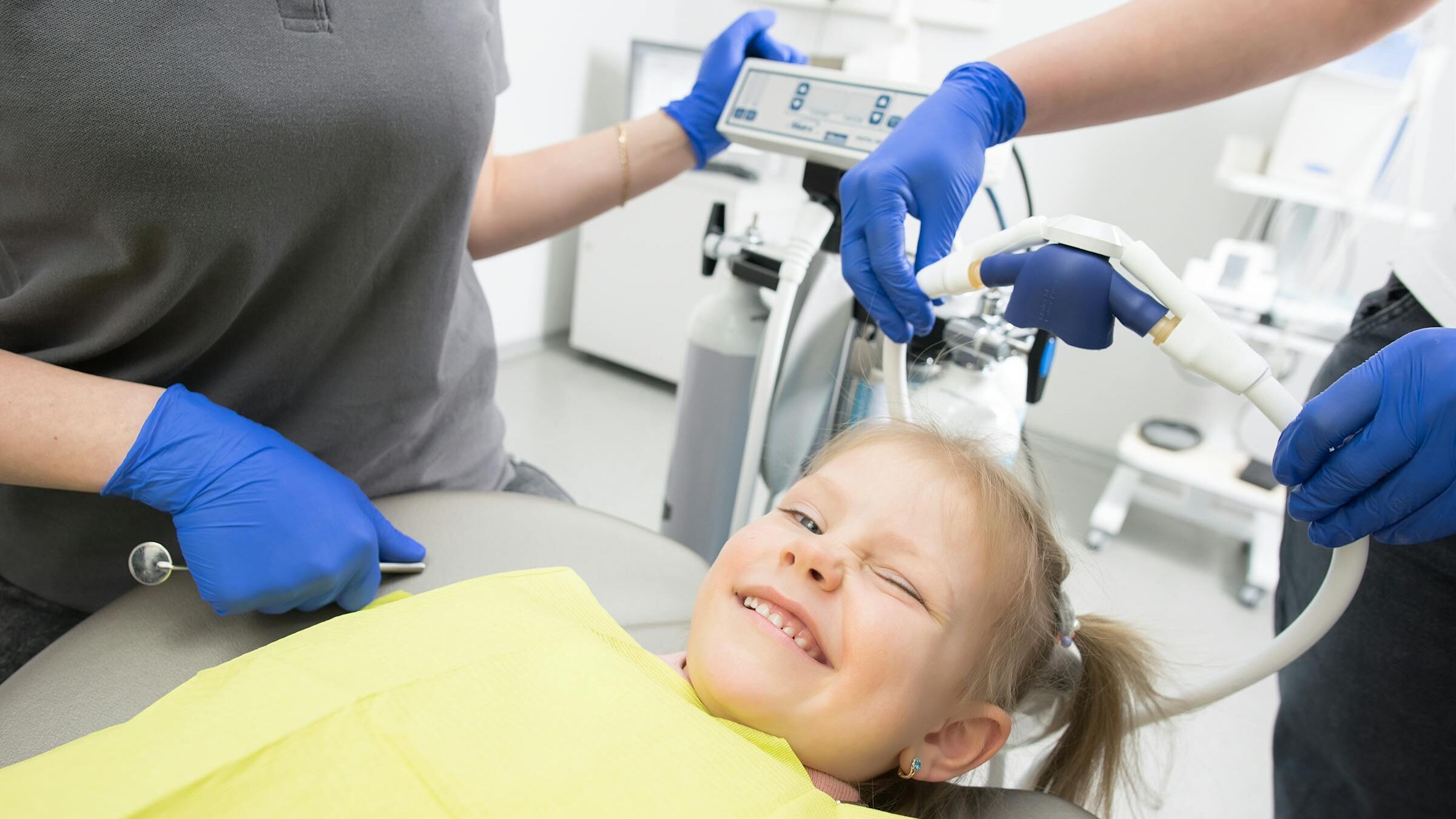 Criança tranquila e a sorrir na cadeira do dentista, sem medo, durante consulta no Instituto Médico e Dentário Dra. Sara Martins