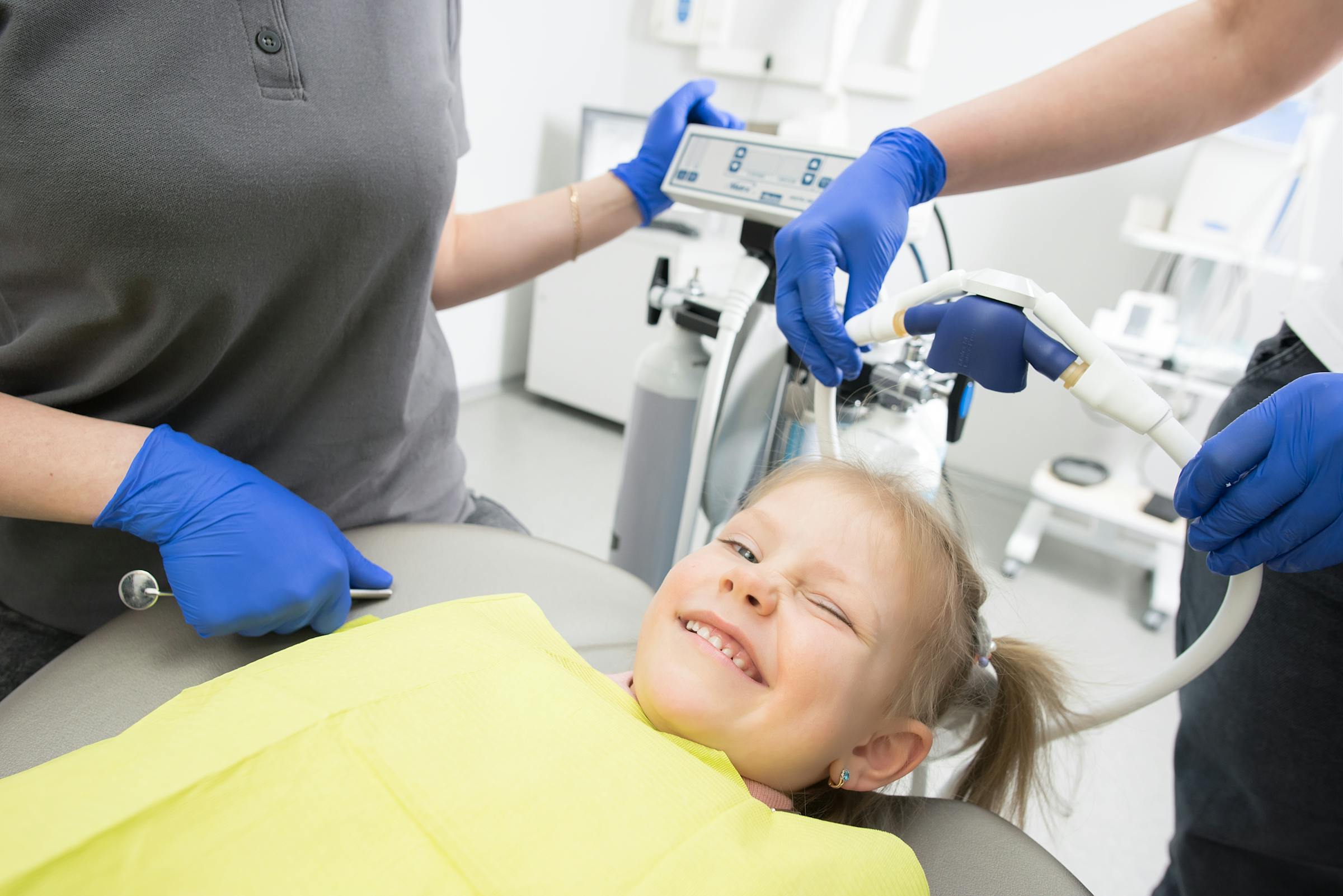 Criança tranquila e a sorrir na cadeira do dentista, sem medo, durante consulta no Instituto Médico e Dentário Dra. Sara Martins